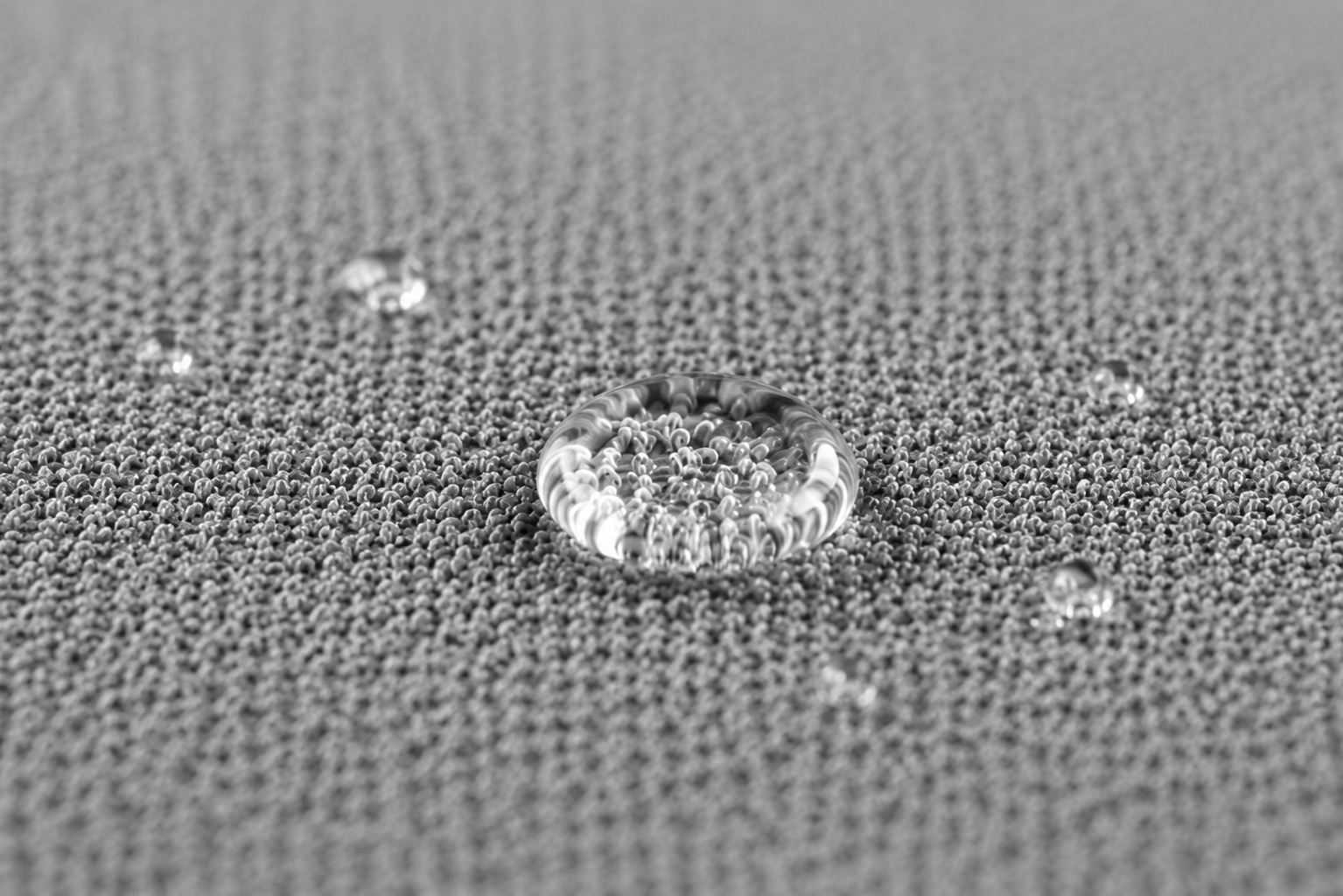 Fine grey textile surface with water-resistant droplets for pet-rest applications